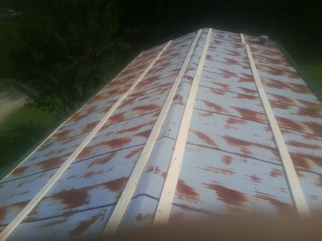 Rusted metal roof panels with new wood purlins before replacement — Storm Damage Roof Repair in Barry by Roofing Brothers
