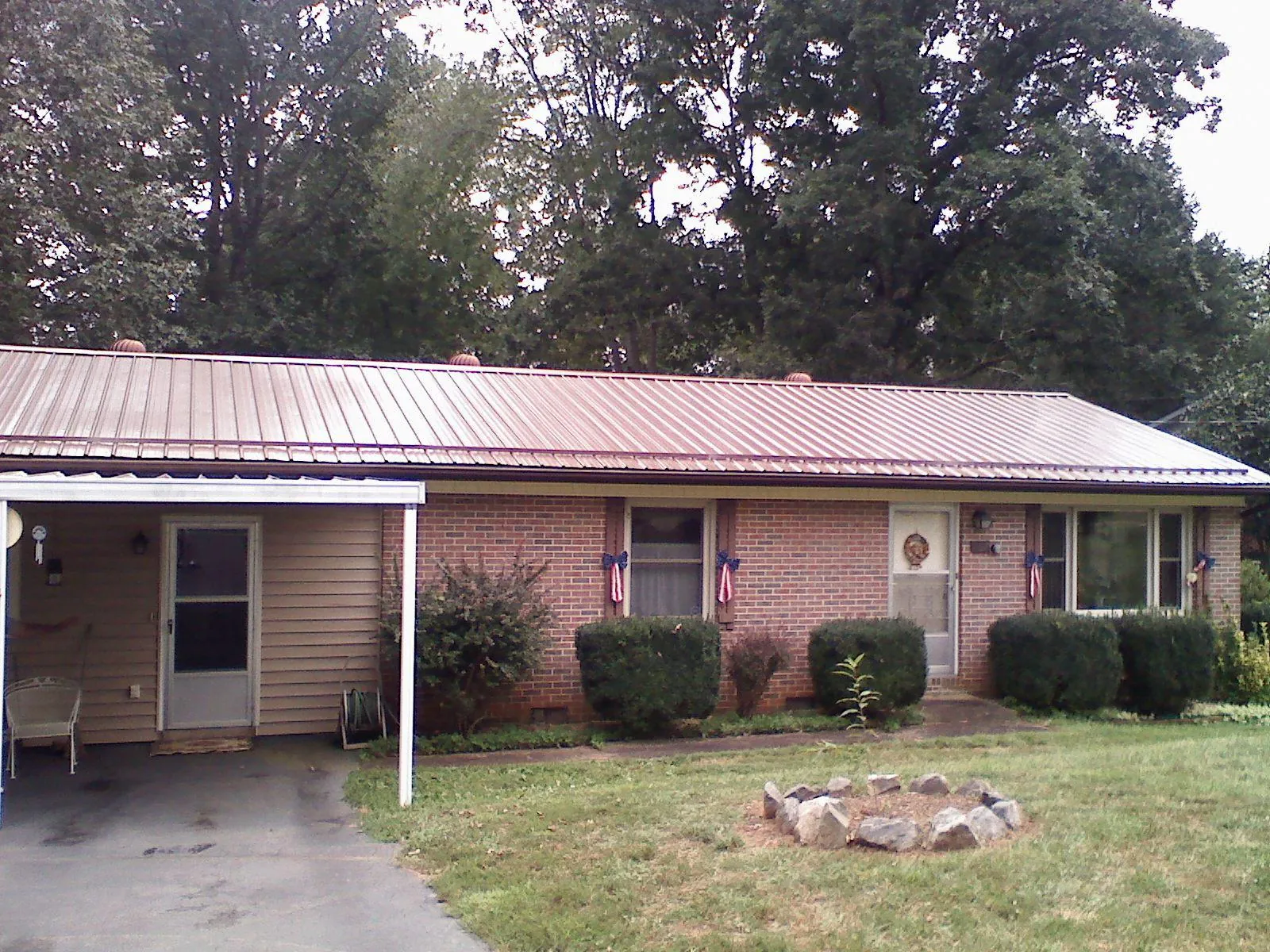 Bronze metal roof and carport on a brick ranch home — Roof Repair work by our crew in Barry